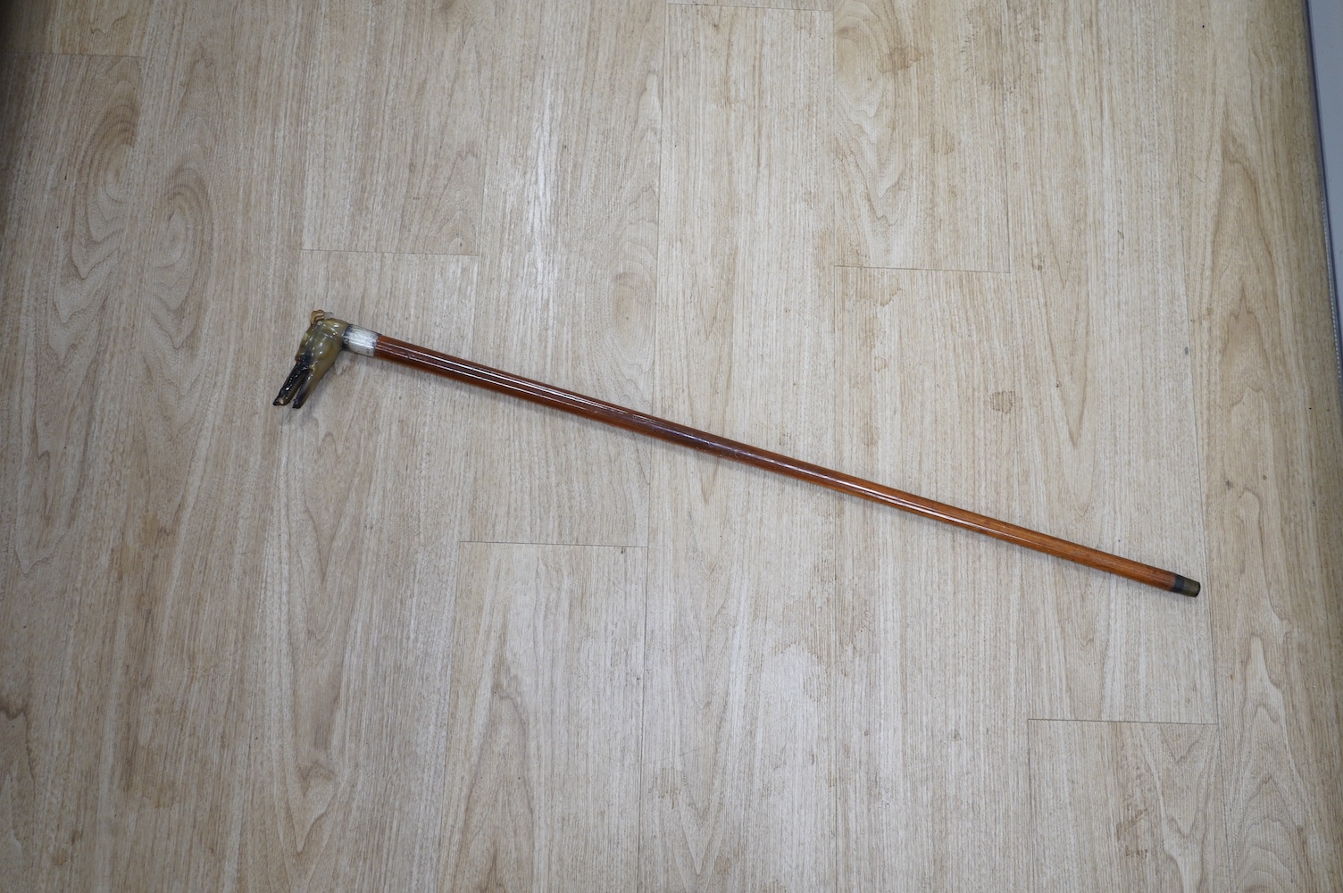 A carved horn ‘greyhound’ handled and silver collared Malacca walking cane, 90cm. Condition - fair to good